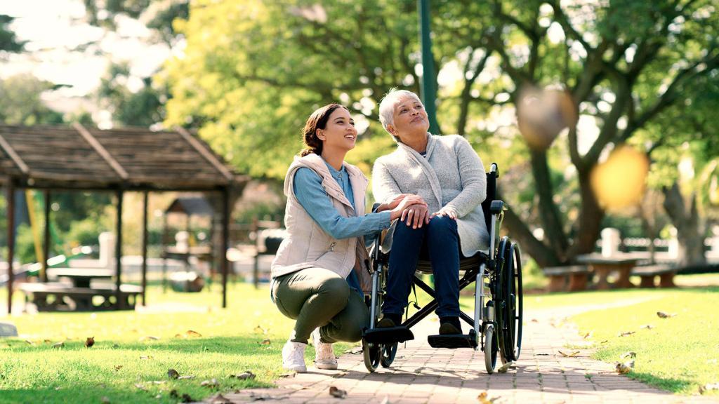 Woman in wheelchair with granddaughter outside on a walk