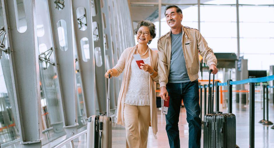 A couple walking through the airport with their bags