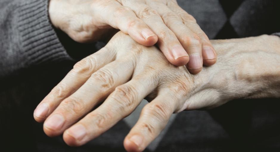 Close up of person's hands, one hand placed on top of the other