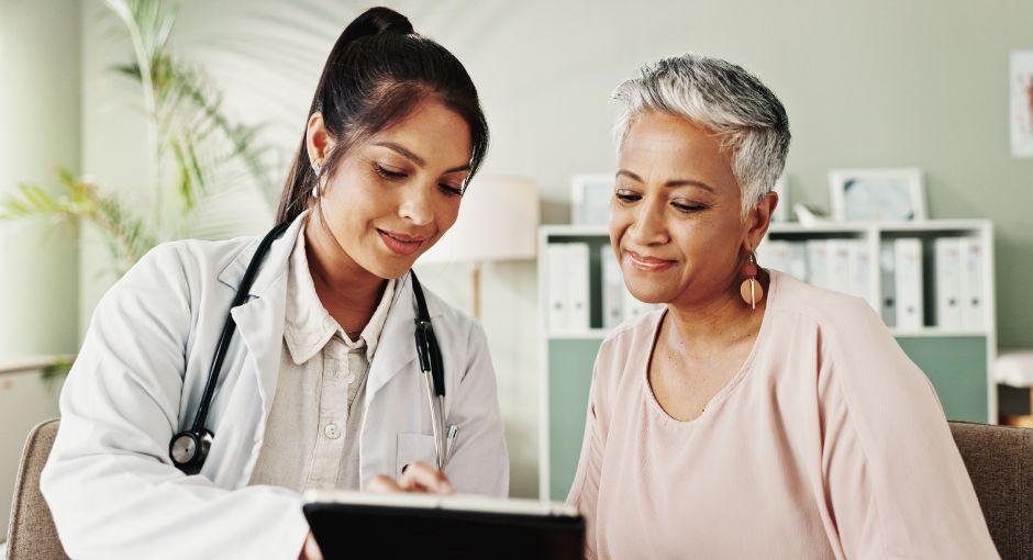 Doctor and senior woman looking at tablet together