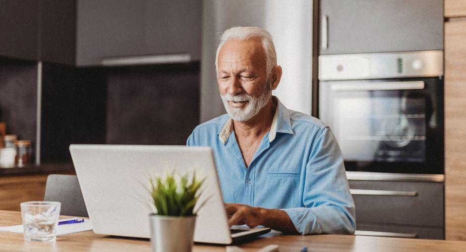 Senior man using his laptop at home